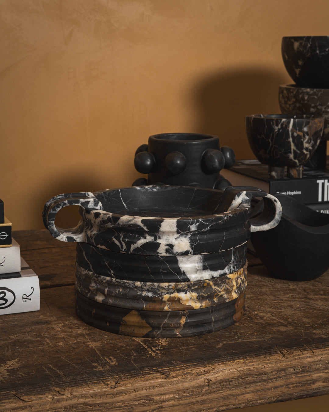 Dark veined marble vessels and bowls on a wooden table