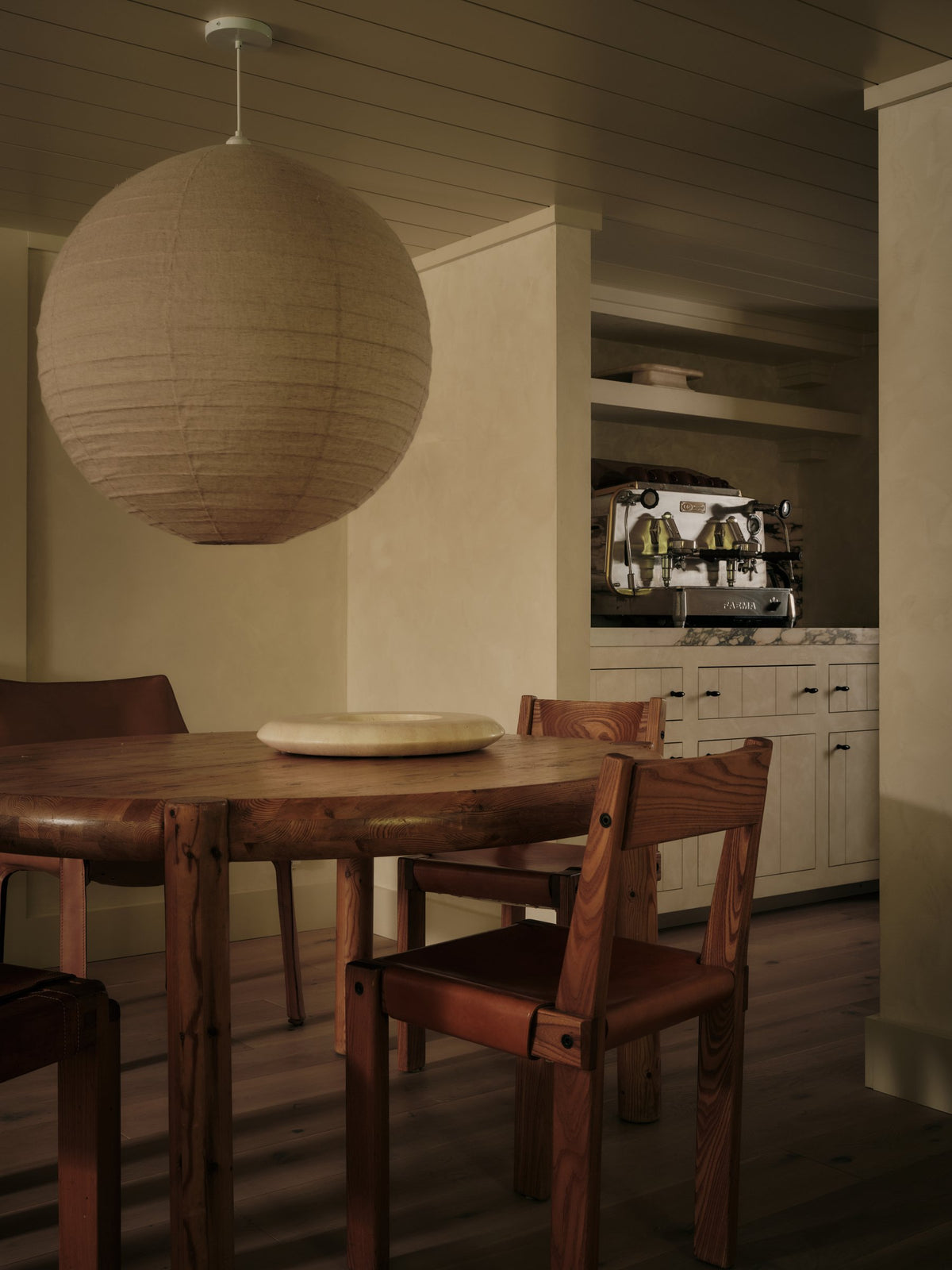 Luna Linen Shade in Taupe above a dining table with the kitchen beyond