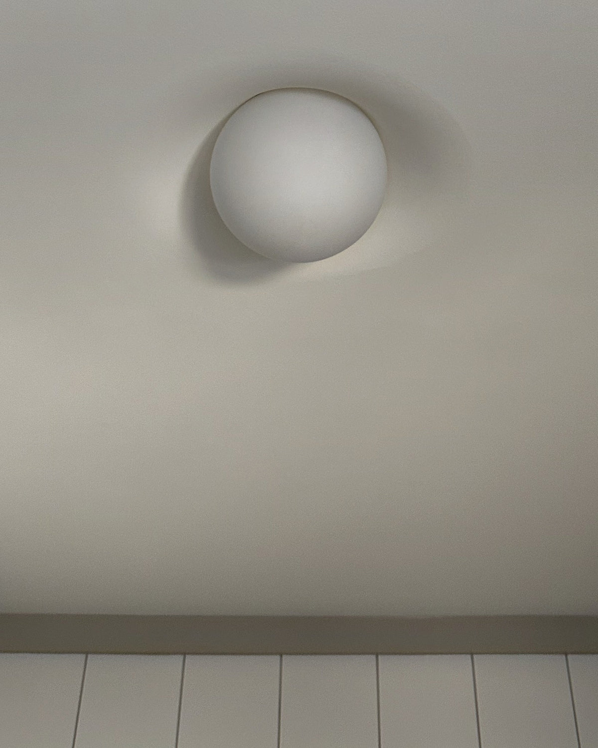 Tommy Plaster Flushmount ceiling light in a bedroom ceiling above panelled walls