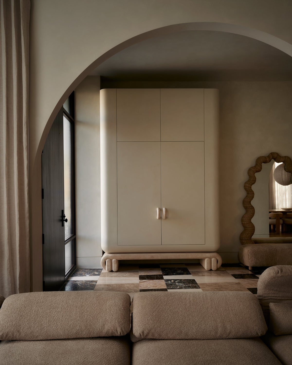 A plaster armoire in an arched alcove with sculptural stone handles
