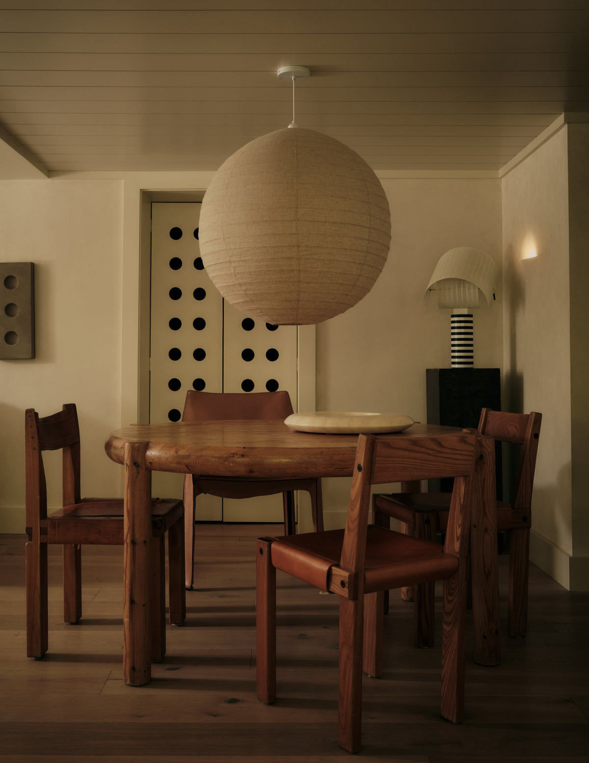 Dining room with a paper globe pendant, round wood table and vintage wood chairs
