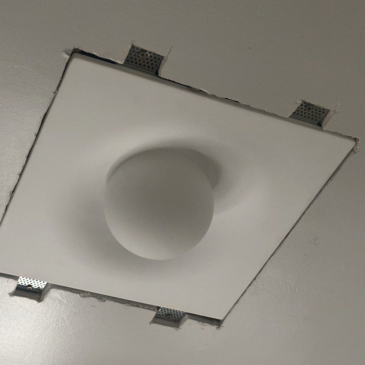 Tommy Plaster Flushmount during installation, square plaster body with mounting brackets before plastering in
