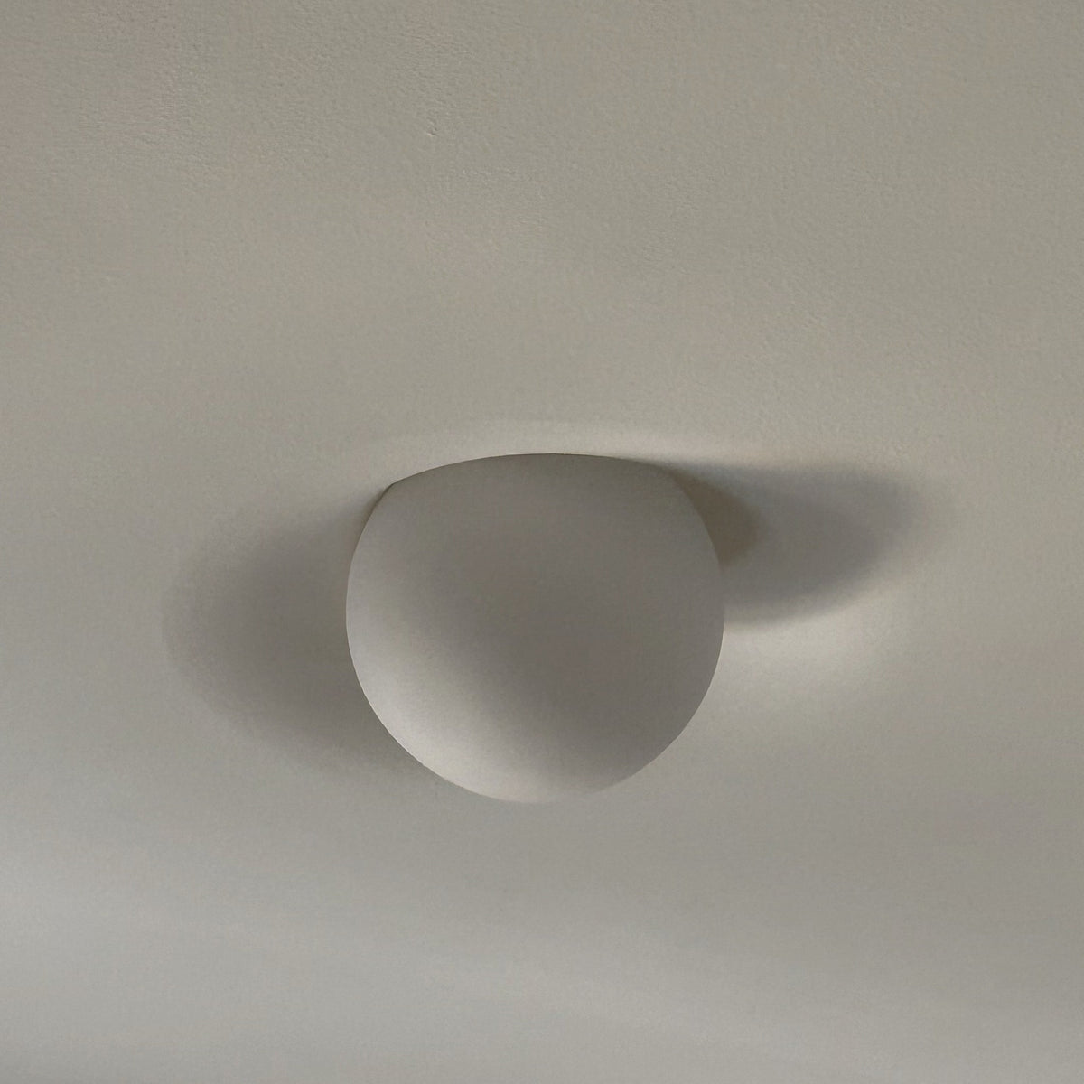 Tommy Plaster Flushmount, side view of frosted globe set flush into a plaster ceiling